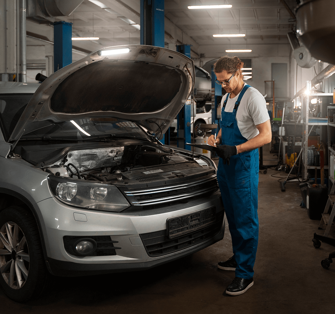 male-mechanic-working-shop-car